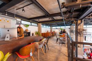 Indie Hostel - Koh Tao في كو تاو: مطعم فيه بار والناس جالسين على الطاولات