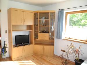 een woonkamer met houten kasten en een flatscreen-tv bij Appartement-Reintalersee in Kramsach