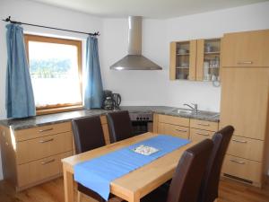 een keuken met een houten tafel met stoelen en een raam bij Appartement-Reintalersee in Kramsach