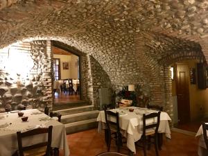 uma sala de jantar com duas mesas e uma parede de pedra em Agriturismo Antica Dimora Del Turco em Sona