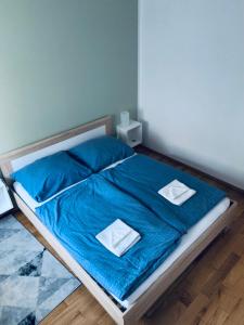 łóżko z niebieską pościelą i białymi ręcznikami w obiekcie Listopadowa43 - z garażem w Bielsku Białej