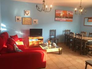 a living room with a red couch and a table at Casas Encinares in Narrillos de San Leonardo