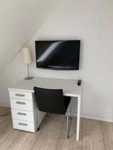 a white desk with a television on a wall at Fishermans House in Hirtshals