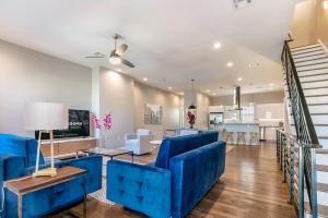 a living room with blue furniture and a kitchen at Stunning Villas with Modern & Open Layout in New Orleans