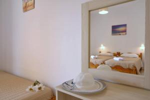 a mirror in a room with two beds and a hat at Makris Apartments Arillas Corfu in Arillas