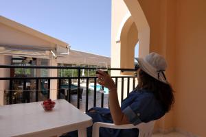a woman sitting at a table with a glass of wine at Makris Apartments Arillas Corfu in Arillas