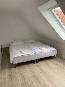 a white bed in a room with a window at Fishermans House in Hirtshals