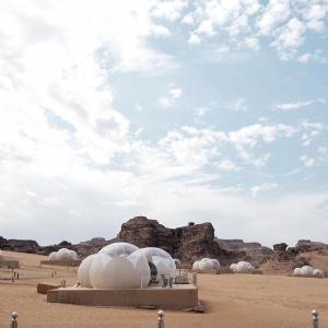a group of domes in the desert under a cloudy sky at Wadi Rum Bubble Luxotel in Wadi Rum