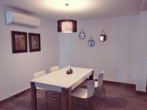 a dining room with a white table and chairs at Alojamientos 4nudos in San José