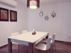 a dining room with a white table and chairs at Alojamientos 4nudos in San José
