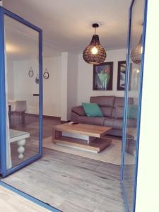 a living room with a couch and a mirror at Alojamientos 4nudos in San José