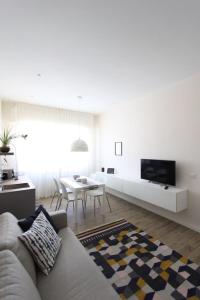 a white living room with a couch and a tv at LA CASABELLA in Terralba