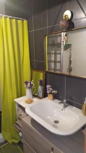 a bathroom with a sink and a yellow shower curtain at Apartamento Boho Chic Costa da Morte A Favela in Neaño
