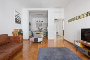 uma sala de estar com um sofá e uma mesa em Roomy Apartment Duomo & San Babila em Milão