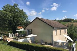 a house with a patio with chairs and umbrellas at Atelier des Rêves in Vichy