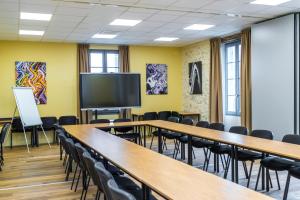 d'une salle de conférence avec des tables et des chaises et une télévision à écran plat. dans l'établissement Clos Castel Villas, à Casteljaloux