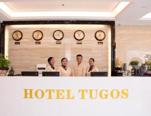 a group of people standing behind a hotel tucos counter at Hotel Tugos in Baguio