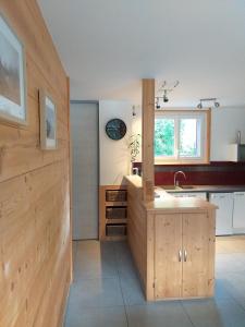 a kitchen with wooden cabinets and a sink in it at Le mas des Alberges in Le Bourg-dʼOisans