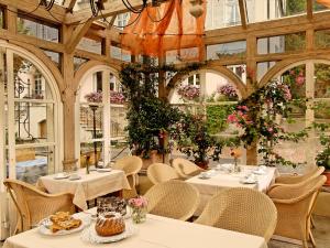 ein Restaurant mit Tischen, Stühlen und Blumen in der Unterkunft Landhotel Zum Bären in Balduinstein