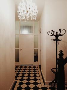 a hallway with a white door and a chandelier at GUESTHOUSE UIT DE KUNST in Leeuwarden