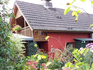 una casa roja con un jardín delante en Appartement Rose en Hechthausen