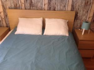 a bed with two white pillows and a wooden headboard at Nice stay in Madrid