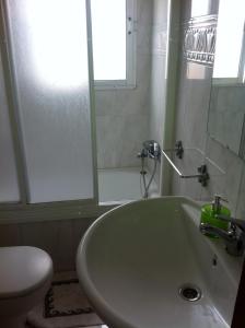 bagno con lavandino, servizi igienici e specchio di Pensión Ruiz a Linares