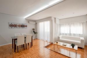 バレンシアにあるLight and bright apartment in central Valenciaのリビングルーム(テーブル、椅子、ソファ付)