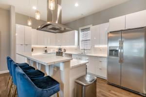 a kitchen with white cabinets and a refrigerator at Fully-Furnished Townhouse with Luxury Amenities in New Orleans