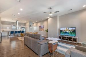 a living room with a couch and a tv at Fully-Furnished Townhouse with Luxury Amenities in New Orleans
