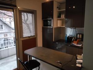 a small kitchen with a table and a balcony at Appartement 2 pieces 40 m2, dans hyper centre, avec piscine au rez de chaussee in Grenoble