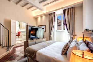 Un dormitorio con una cama grande y un televisor de pantalla plana. en Eitch Borromini Palazzo Pamphilj, en Roma 125 fotos más