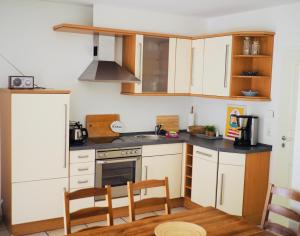 a kitchen with white cabinets and a stove top oven at 100 Sekunden zum Strand: Schöne Wohnung auf Usedom in Ostseebad Karlshagen