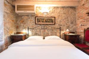 una camera con un letto in una parete in pietra di Holiday Home Bozanić a Vrbnik