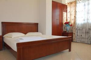 1 dormitorio con 1 cama grande y cabecero de madera en Ionian Seaview, en Himare