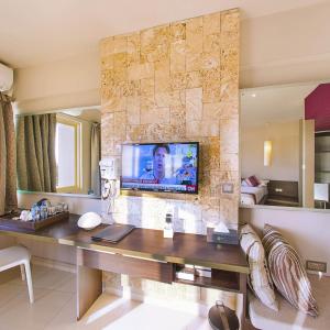 sala de estar con TV en una pared de piedra en Bliss Resort, en Nyali