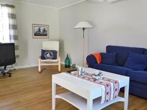 a living room with a blue couch and a coffee table at Three-Bedroom Holiday home in Lysekil 4 in Lysekil