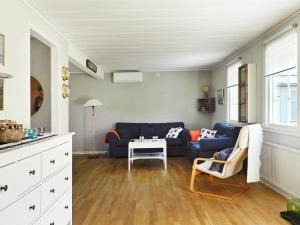 a living room with a blue couch and a table at Three-Bedroom Holiday home in Lysekil 4 in Lysekil