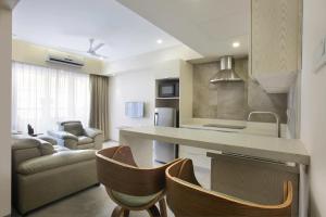 a kitchen and living room with a counter and chairs at Floressa Randa Business Hotel in Chennai