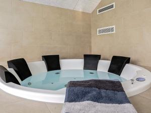 a circular glass table with chairs in a bath tub at 14 person holiday home in Idestrup in Marielyst