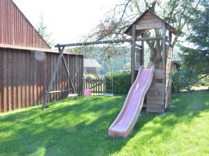 a wooden playground with a slide in a yard at Rural lodging located in the small village of Radelange 100 Nature in Radelange