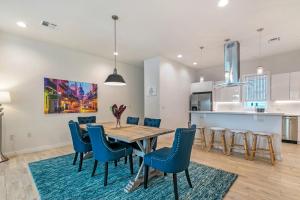 a kitchen and dining room with a wooden table and blue chairs at Stunning Townhouse with Amenities in New Orleans