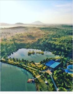 una vista aérea de un lago con árboles y agua en "D'BAMBOO KAMP" Desa Wisata Ekang en Lagoi