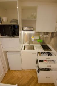 a kitchen with white cabinets and a sink and a microwave at Studio Stil in Belgrade