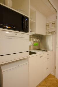 eine Küche mit weißen Schränken und einer Mikrowelle in der Unterkunft Studio Stil in Belgrad