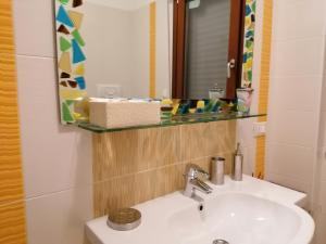 een badkamer met een wastafel en een spiegel bij Appartamento elegante nuovissimo in Quartu SantʼElena