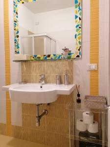 クアルトゥ・サンテーレナにあるAppartamento elegante nuovissimoのバスルーム(白い洗面台、鏡付)