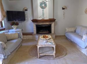 a living room with a fireplace and a coffee table at Petrameli in Karpenisi