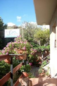 a garden with flowers and a sign on a building at Hotel Signorini in Castiglioncello