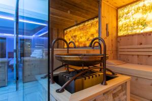 a sauna with a copper bowl on a stove at Hotel Anemone in Lech am Arlberg